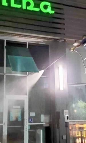 Pressure washing service cleaning storefront windows and exterior surfaces in California.