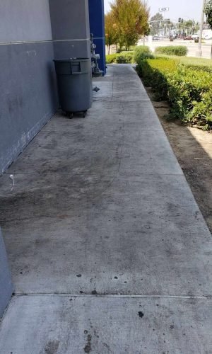 Commercial sidewalk being pressure washed in California for cleaning and maintenance.
