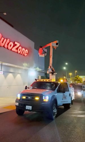 Pressure washing truck with lift equipment at AutoZone for exterior cleaning services.
