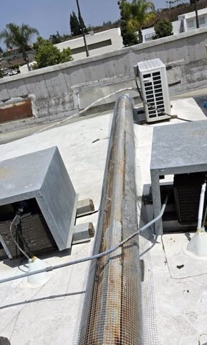 High-pressure cleaning equipment on a building rooftop in California for exterior surface cleaning.