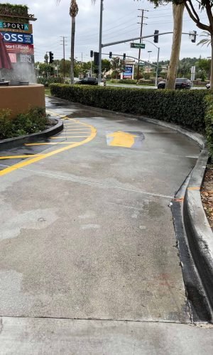 Pressure washing driveway with professional equipment in California.