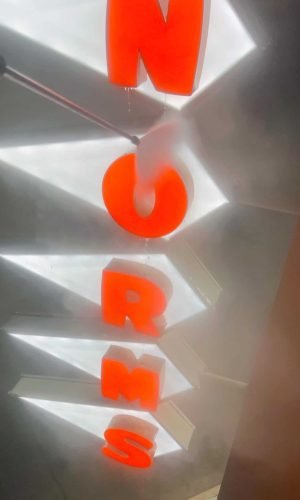 Bright orange "PRESSURE WASH" sign on metallic background for exterior cleaning services.