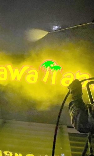High-pressure cleaning of a wall with a professional pressure washer in California.